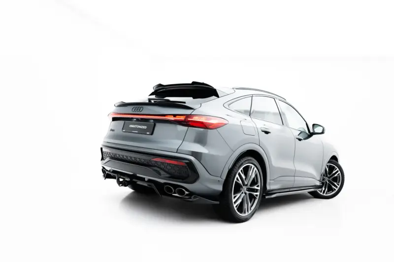 Rear three-quarter view of a silver Audi SUV with a black roof spoiler and red taillights visible at the back, including a license plate reading #MAXTONIZED.