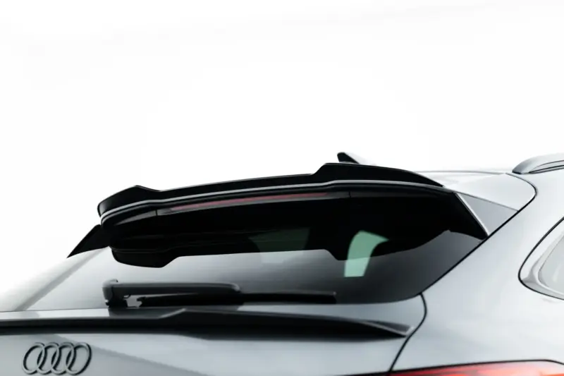 Rear view of a silver Audi with a dark rear window, wiper, and visible emblem on the trunk lid.