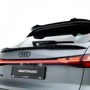 Rear view of a silver Audi with illuminated taillights, visible quattro badge, and a spoiler; the license plate area shows the text #MAXTONIZED.