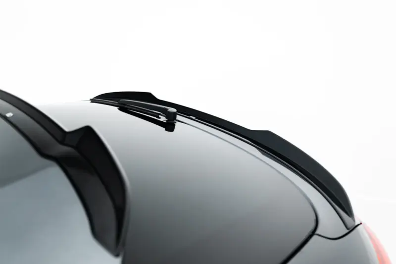 Close-up of a car windshield wiper resting on a black glossy hood.