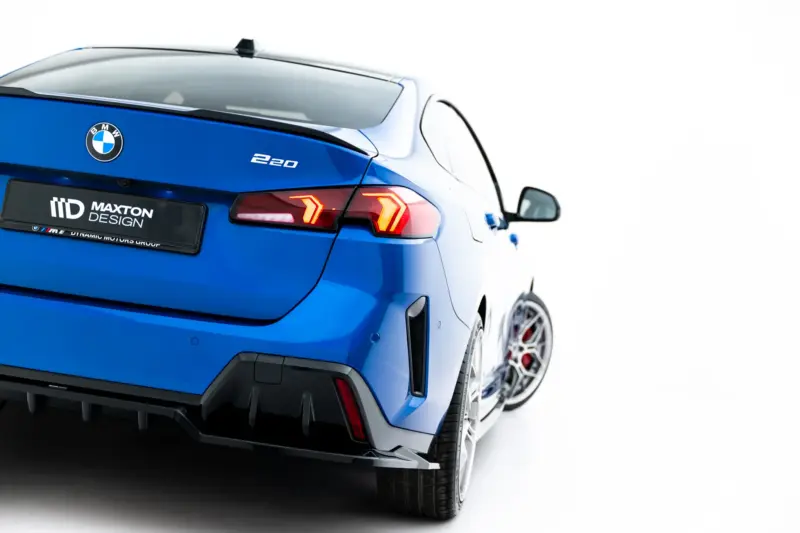 pol_po_Set-of-Splitters-BMW-2-M-Pack-Gran-Coupe-F74-23856_6webp - OPSHOLDERS Rear view of a blue BMW showing the '220' badge and Maxton Design plate on a white background, illuminated tail lights visible.