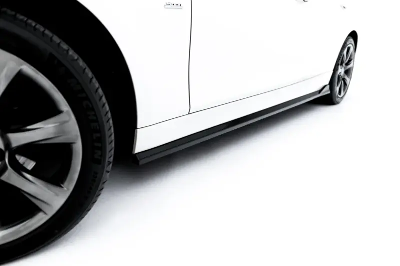 Close-up of a white car's side showing the door seam and wheel on a white background, angled view.