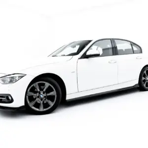 White BMW sedan shown from a three-quarter front view against a bright studio background, highlighting its sleek body and alloy wheels.