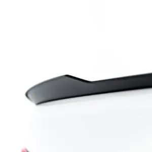 Close-up of a white car showing a black roof trim and the BMW emblem on the trunk.