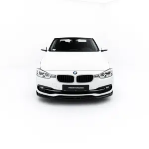 Front view of a white BMW car in a clean studio setting, showing the kidney grille and headlights.