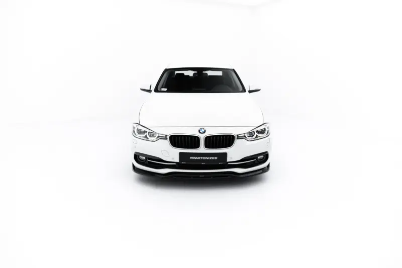 Front view of a white BMW car in a clean studio setting, showing the kidney grille and headlights.