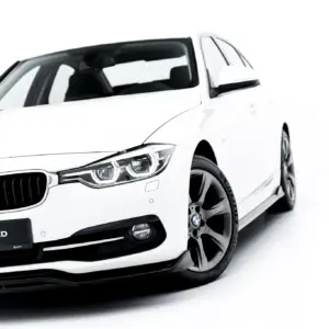 White BMW car shown from a low front-left angle, showcasing the grille, headlight, and alloy wheel with #MAXTONIZED license plate area.