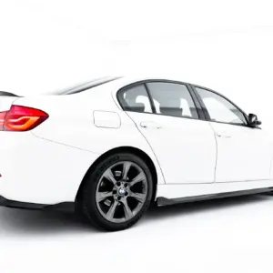 White BMW sedan viewed from the rear-left side, showing taillight and trunk in a studio setting on a white background.