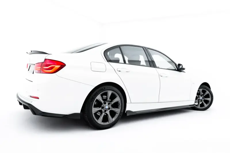 White BMW sedan viewed from the rear-left side, showing taillight and trunk in a studio setting on a white background.