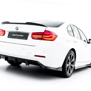 Rear view of a white BMW sedan with red taillights, spoiler, and alloy wheels; license plate reads #MAXTONIZED.