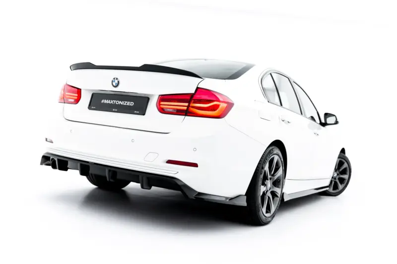 Rear view of a white BMW sedan with red taillights, spoiler, and alloy wheels; license plate reads #MAXTONIZED.