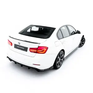 White BMW sedan photographed from a rear three-quarters against a white background, showcasing taillights and spoiler.
