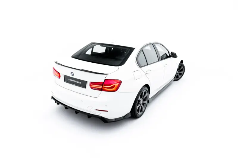 White BMW sedan photographed from a rear three-quarters against a white background, showcasing taillights and spoiler.