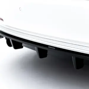 Close-up of a white car rear bumper with a black lower panel and a Maxton Design badge.