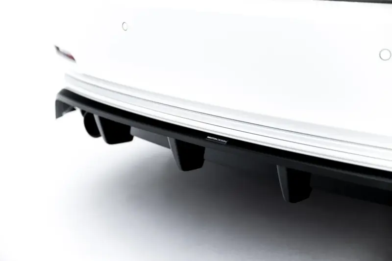 Close-up of a white car rear bumper with a black lower panel and a Maxton Design badge.