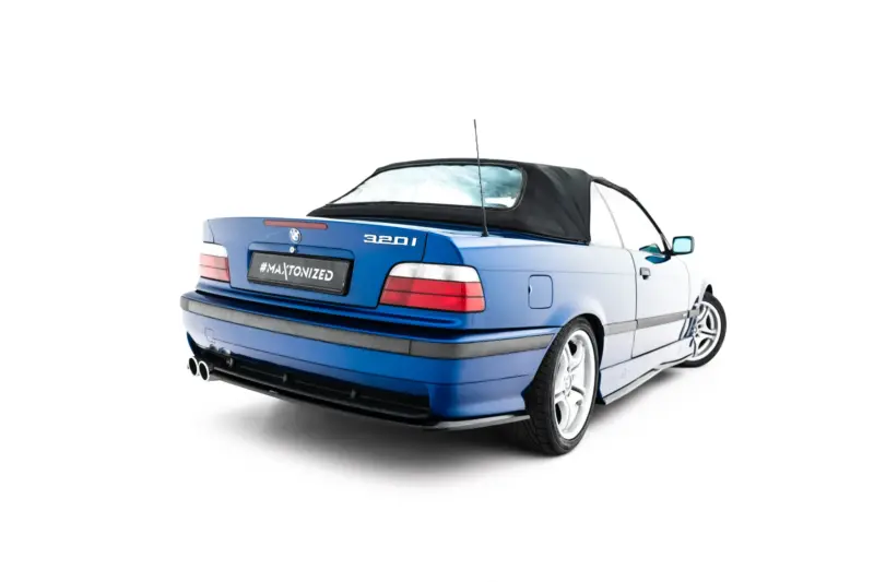Rear three-quarter view of a blue BMW 320i convertible with a black soft top up, against a white background.