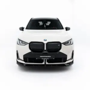 Front view of a white BMW SUV in a bright studio, showing the prominent kidney grille, LED headlights, and black lower bumper with a #MAXTONIZED license plate.
