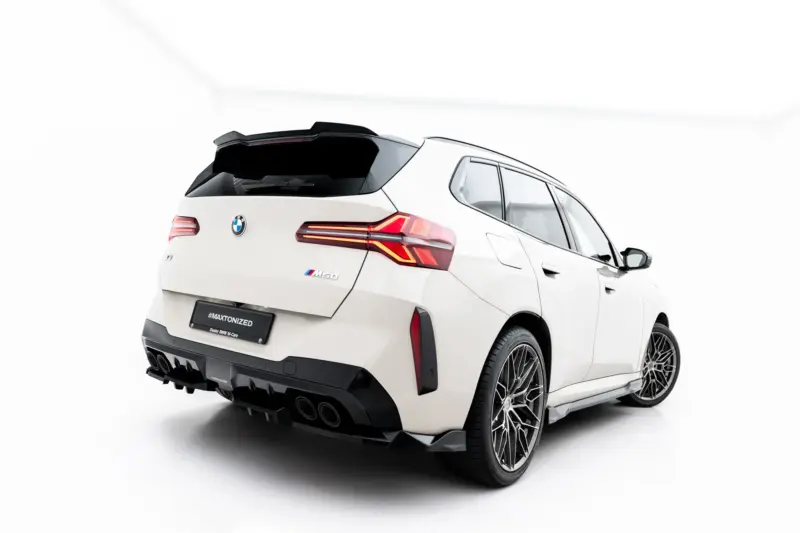 Rear three-quarter view of a white BMW SUV, showing distinctive taillights, quad exhausts, and large alloy wheels.