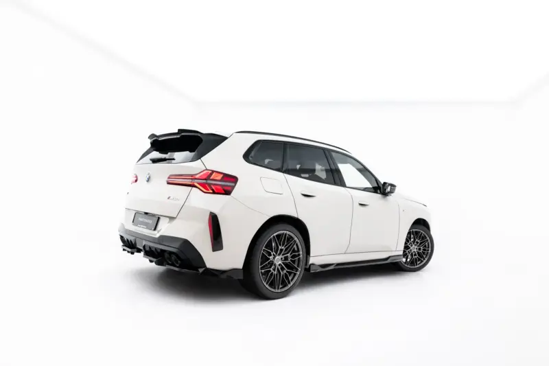 Rear three-quarter view of a white BMW SUV with the tailgate open in a bright studio setting.