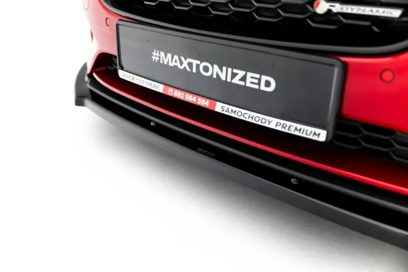Close-up of a red car's front bumper showing a license plate with the hashtag '#MAXTONIZED' and a slogan strip reading 'DRIVE YOUR DREAM'.