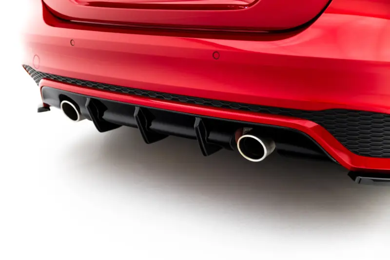 Rear bumper of a red car showing dual exhaust pipes and a black diffuser area close up of the tail end