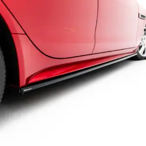 Close-up of a red car's side with a door seam and visible wheel, against a white background.