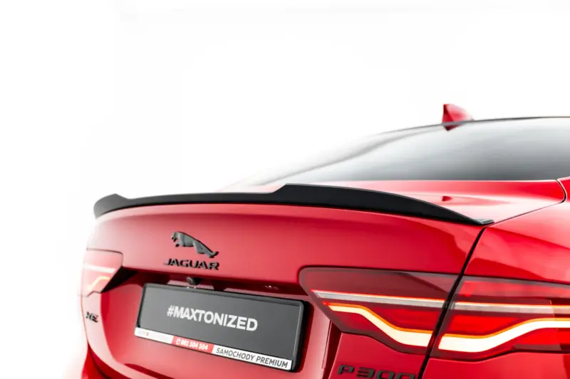 Red Jaguar SUV rear view, showing the Jaguar emblem, taillights, and a license plate reading #MAXTONIZED
