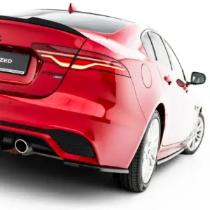 Rear view of a red Jaguar car showing the Jaguar emblem, taillights, and a '#MAXTONIZED' plate on a white background setting.