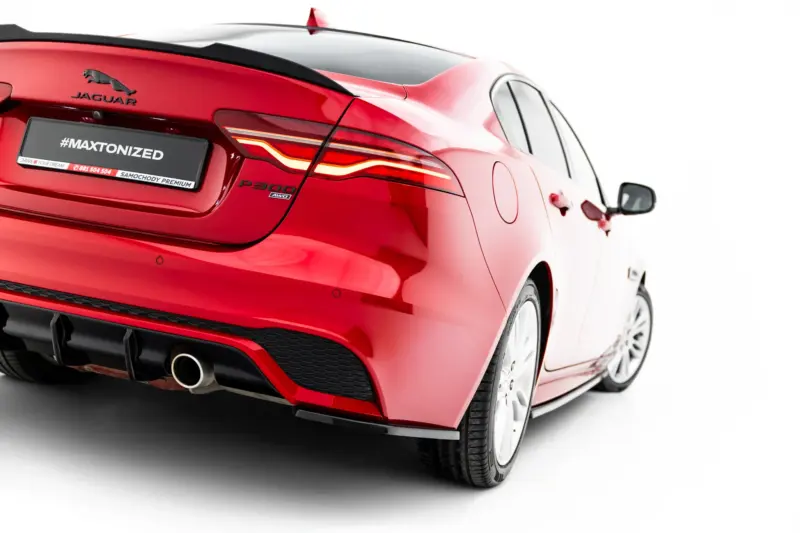 Rear view of a red Jaguar car showing the Jaguar emblem, taillights, and a '#MAXTONIZED' plate on a white background setting.