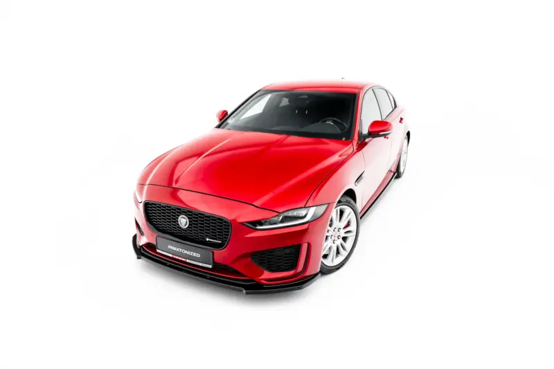 Red Jaguar sedan angled from the front-left against a white background, showcasing its grille and headlights