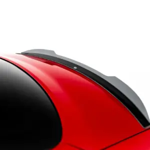 Close-up of a red car roof with a black-tinted windshield and a gray roof spoiler against a white background?