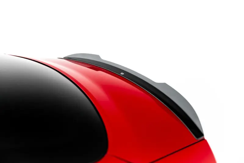 Close-up of a red car roof with a black-tinted windshield and a gray roof spoiler against a white background?