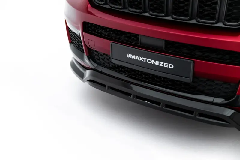 Front end of a red car showing a black grille and a license plate reading #MAXTONIZED on the bumper