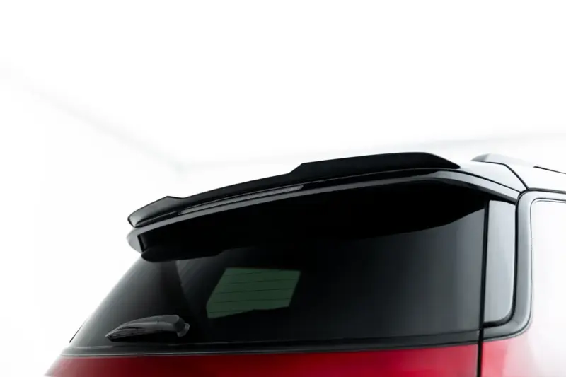Partial view of a car's rear window with wiper, showing dark glass and red body at the bottom edge of the image