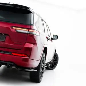 Red Jeep SUV seen from a rear three-quarter angle, showing the taillight, bumper, and a #MAXTONIZED plate on a glossy red finish.