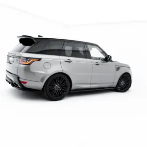 Side and rear view of a silver Range Rover SUV in a bright studio setting with black alloy wheels and tinted windows.