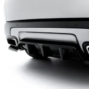 Close-up of a car's rear bumper showing dual exhaust tips and dark diffuser details