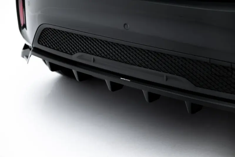 Close-up of a dark car's front bumper with a diamond-pattern mesh grille and a small Maxton Design badge.