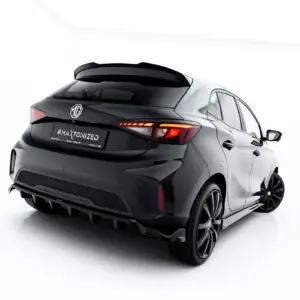 Rear view of a dark MG hatchback with a prominent rear spoiler and illuminated taillights against a white studio backdrop, showing MG logo on the trunk.