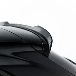 Close-up of a glossy black car surface with smooth curves and reflections against a white background.