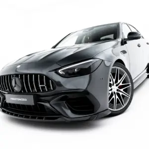 Front three-quarter view of a glossy black Mercedes-AMG sports car on a white studio backdrop, highlighting the aggressive grille and angular headlights.