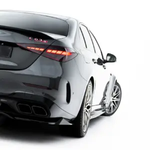 Rear three-quarter view of a metallic gray Mercedes-Benz C63S with a #MAXTONIZED license plate and illuminated tail lights on a white backdrop