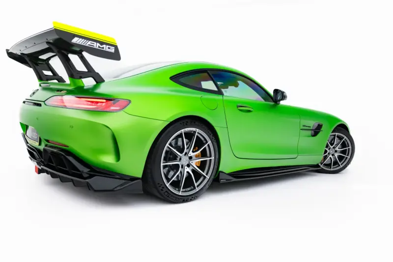 pol_po_Set-of-Splitters-Mercedes-AMG-GT-R-C190-Facelift-23894_3webp - OPSHOLDERS Green high-performance AMG sports car seen from the rear three-quarter view with a large rear wing on a white background