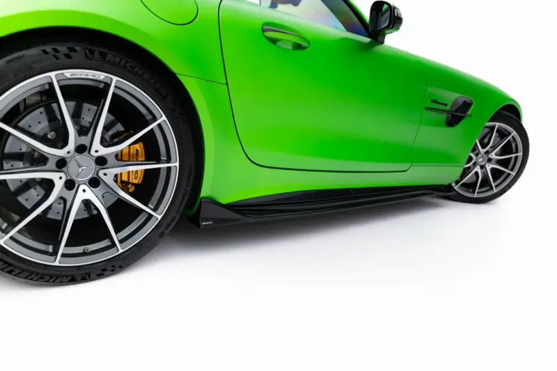 pol_po_Set-of-Splitters-Mercedes-AMG-GT-R-C190-Facelift-23894_4webp - OPSHOLDERS Close-up of a bright green sports car's front left wheel, showing a silver alloy rim and yellow brake caliper visible through the spokes.