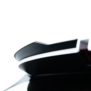 Close-up of a glossy black curved surface on a white background; abstract product shot.