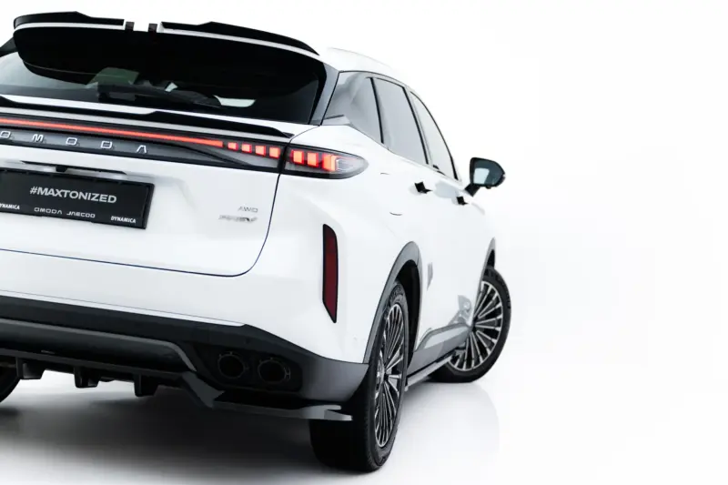 Rear three-quarter view of a white SUV with a red taillight strip and large alloy wheels, MAXTONIZED plate visible.