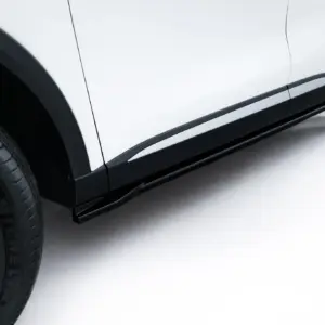 Close-up of a white car's lower side panel with black trim and alloy wheel visible at the edge.