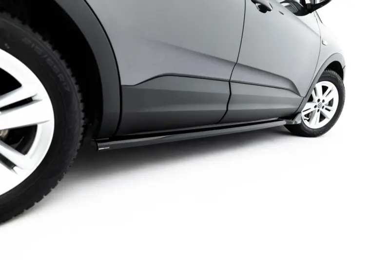 Close-up of a silver SUV side panel and front wheel with white background behind it