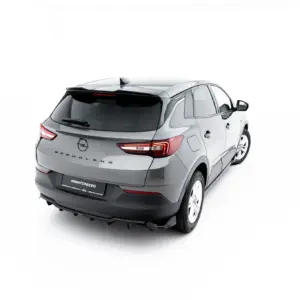 Rear three-quarter view of a silver Opel Grandland SUV against a white studio backdrop, showing taillights and rear design features.