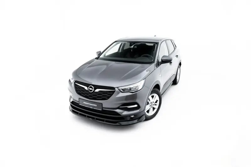 Three-quarter front view of a silver Opel hatchback against a white studio backdrop, showing the grille and headlights.